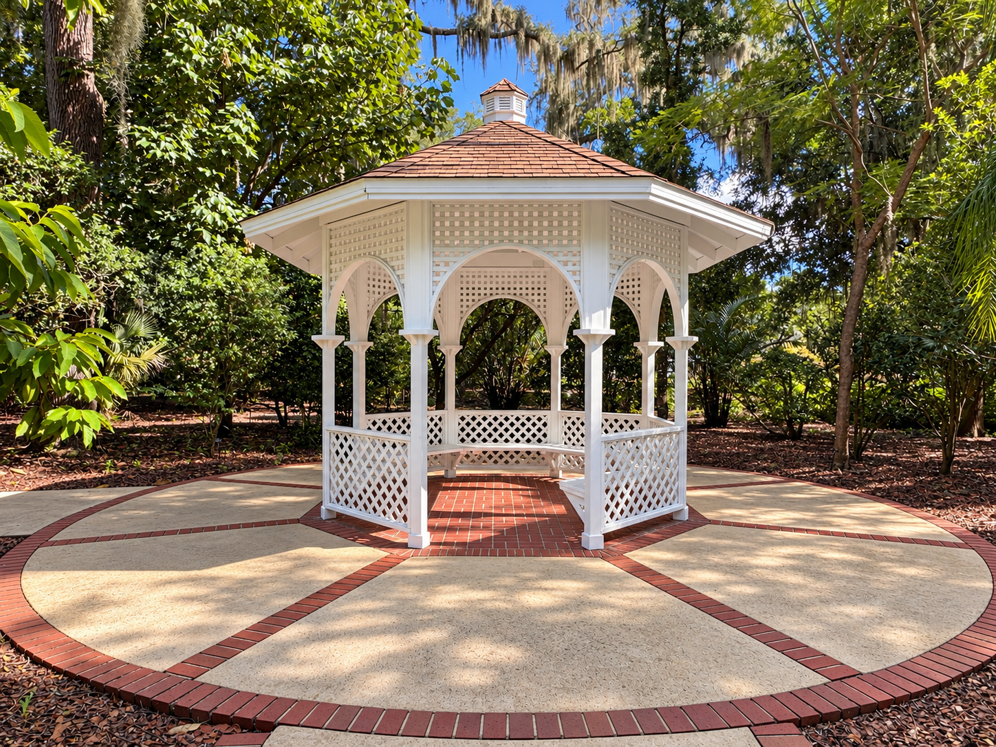 Photo of the South Gazebo wedding site. It features a white gazebo, beige and red bricks, and green trees.