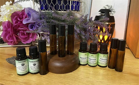 Multiple bottles of aromatherapy oils on a wooden table.