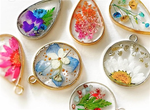 Circle and teardrop-shaped pendants. They have flowers inside them.