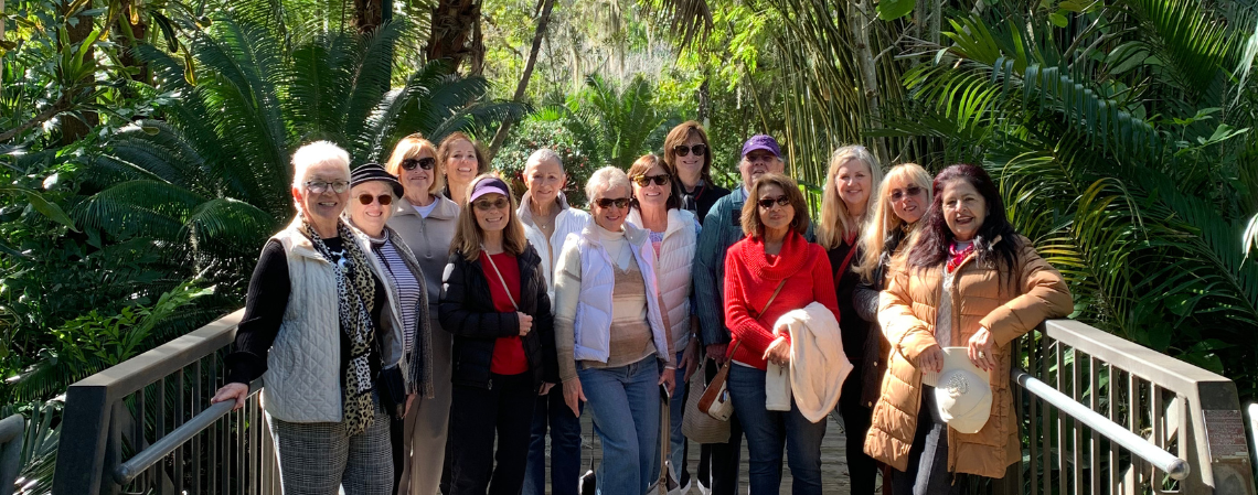 A group of adults standing on a bridge enjoying a tour of the gardens