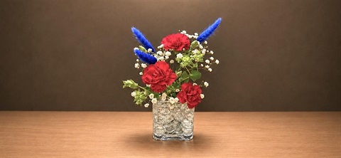 Vase of red, white, and blue flowers.