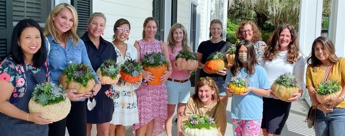 A group of women holding potted succulent plants