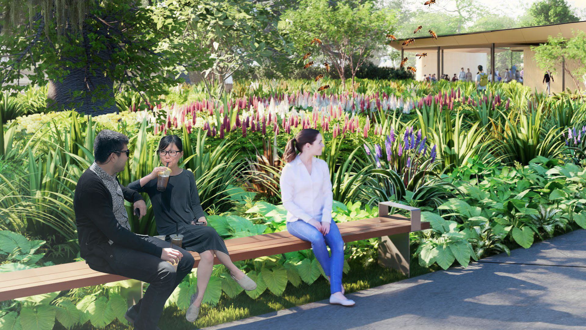 Three individuals sit on a long wooden bench in a lush garden filled with tall green plants and colorful flowers. pavilion with people walking nearby is visible in the background.